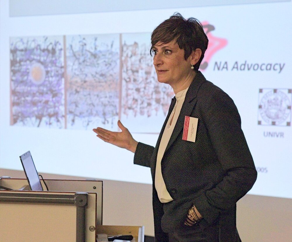 Professor Lucia De Franceschi during a presentation at the NA Symposium