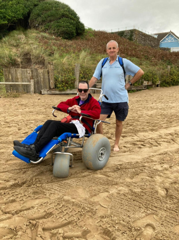 Peter Clark on the beach, in a special wheelchair to have access on sand