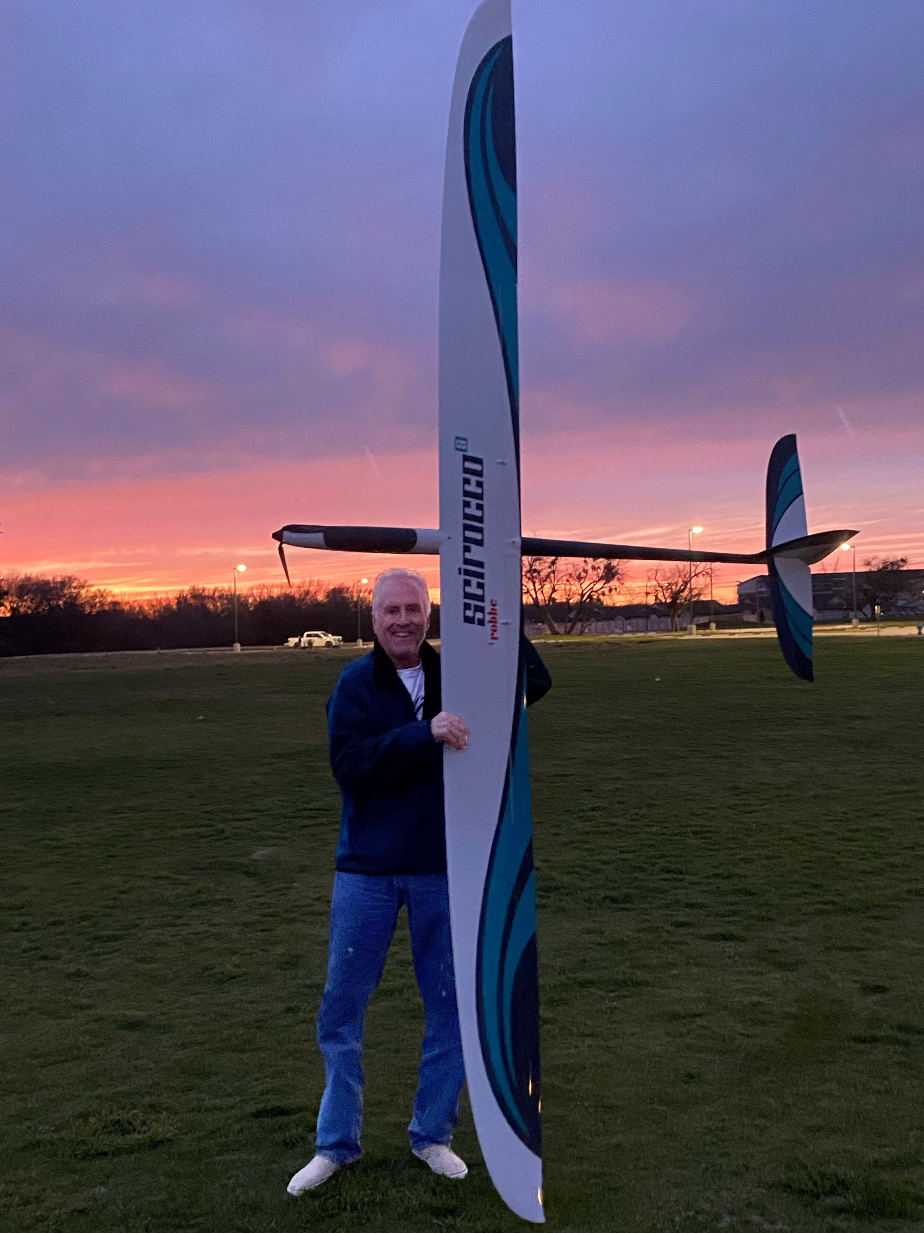 Brad Salzmann holding his glider; beautiful sunset colours in the background